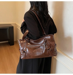 Detail of dark brown tote bag with oily wax leather texture and Noronoro brand logo