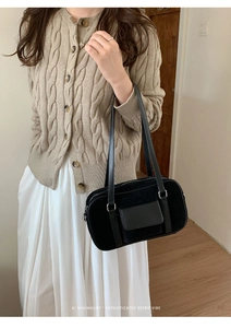 Retro black baguette bag with mixed textures shown in a casual lifestyle scene