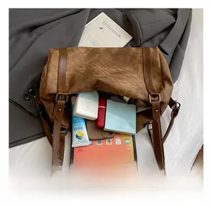 Macro view of spacious interior storage in brown canvas crossbody bag with daily essentials