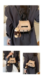 Detail eines Mini-Plüschrucksacks in Khaki mit Leder-Schleife und Bären-Schlüsselanhänger