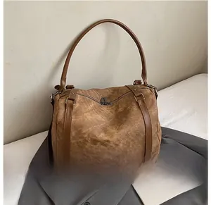 Detail of vintage brown shoulder bag showing crinkled texture and dual zipper closure