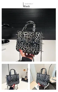 Detail of leopard print tote bag featuring silver rivets and a large cross pendant