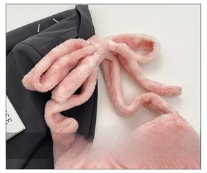 Detail of pink plush shoulder strap featuring a decorative soft ribbon bow design