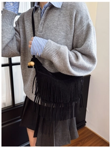 Detail showing bohemian black fringe crossbody bag with wooden beads on shoulder strap