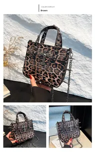 Detail of leopard print crossbody bag with metal cross pendant, rivets and punk spikes