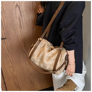Close-up of vintage large capacity handbag featuring light brown texture and dark leather straps