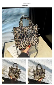 Close-up of leopard print tote bag with silver metal studs and a cross pendant detail
