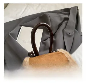 Brown suede backpack with faux fur trim and bow detail on elegant hard handle