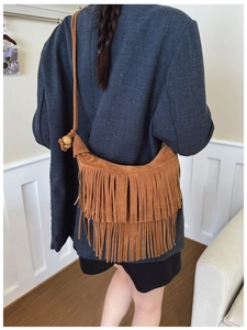 Detailed back view of brown suede crossbody bag with long tassels and wooden beads