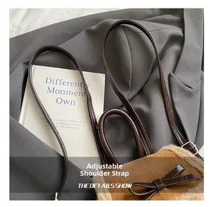 Detail view of brown plush bucket bag with adjustable leather strap and bow accent