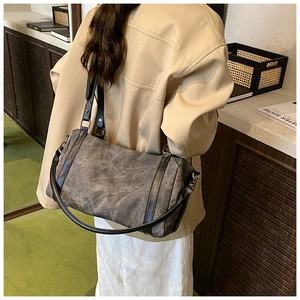 Detail of dark grey cylinder boston bag showing vintage wrinkled texture and straps