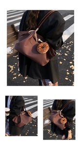 Detail of coffee brown felt tote bag with ribbon bow and donut plush charm on street