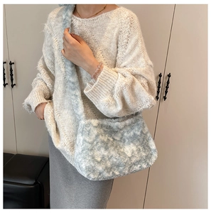 Close-up of blue and white plush shoulder bag worn with a casual knit sweater