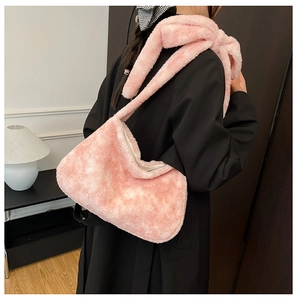 Détail d'un sac à épaule en peluche rose avec bandoulière douce en fausse fourrure