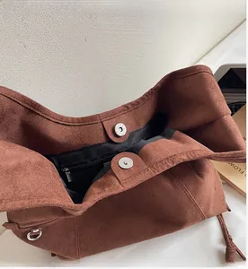Detail der braunen Wildledertasche mit Magnetverschluss und innerem Reißverschlussfach