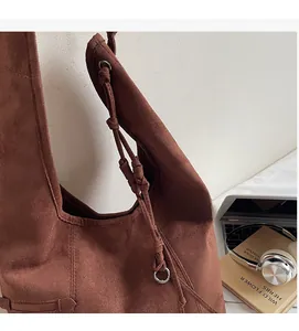 Detail der Wildleder-Einkaufstasche mit geknotetem Riemen und silberner Ringschnalle