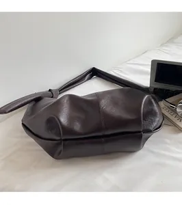 Close-up of knot detail on soft brown faux leather shoulder bag with minimalist finish