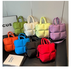Plusieurs sacs cabas matelassés colorés avec bandoulières présentés sur un canapé en cuir