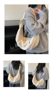 Detailed close-up of cream soft leather crescent bag with knot strap and metal ring detail