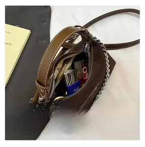 Vue intérieure du sac à main en daim marron avec chaîne argentée et espace de rangement
