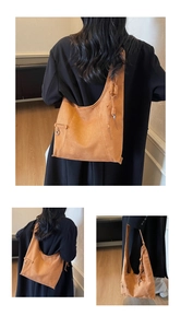 Nahaufnahme der braunen Wildleder-Beuteltasche mit Zierriemen und Metallringen
