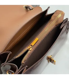 Close-up of brown vintage handbag interior with zipper compartment and gold hardware