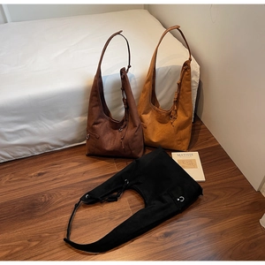 Drei minimalistische Wildleder-Beuteltaschen in Dunkelbraun, Camel und Schwarz mit Knotengriff