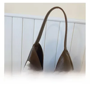 Detail of comfortable carry handle on retro brown bag with silver studded rivets