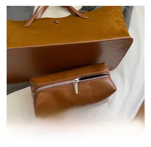Detail of caramel brown tote bag showing mixed leather textures and silver hardware