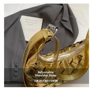 Detail der verstellbaren Silberschnalle an einer gewebten metallisch goldenen Tasche