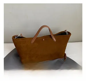 Detailed macro view of dark brown suede tote bag featuring silver hardware and a round snap