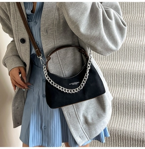 Détail du sac hobo noir mat avec chaîne argentée et bandoulière en cuir marron