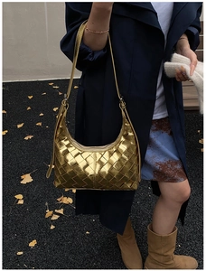 Goldene geflochtene Hobo-Bag mit Metall-Textur, getragen als elegante Schultertasche