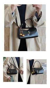 Close-up of the black patent leather handbag featuring a gold twist-lock and knot detail