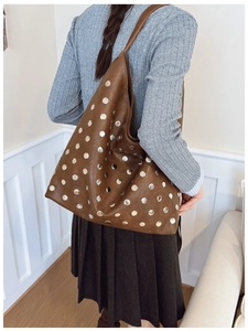 Macro detail of brown leather hobo bag with vintage silver stud rivets decoration