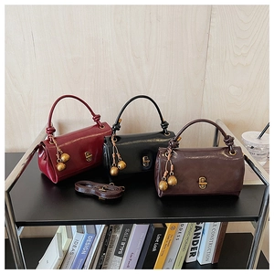 Detailed shot of stylish leather handbags with knot handles and golden metal tassels