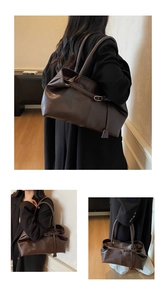 Détail du sac cabas en cuir marron foncé montrant les boucles en métal et la texture