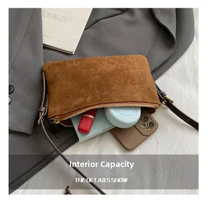Vista detallada del interior de bolso de ante marrón con capacidad para objetos diarios