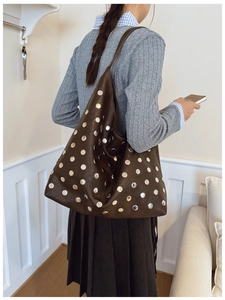 Detailed side view of deep coffee hobo bag featuring silver metal rivet decorations