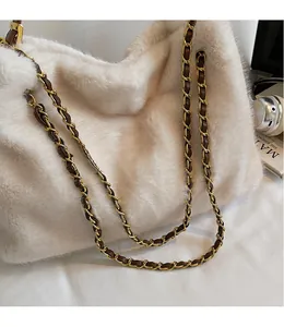 Détail du sac à bandoulière en peluche crème avec chaîne dorée et texture en fausse fourrure
