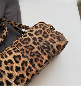 Gros plan détaillé de la texture léopard et des ferrures argentées sur un sac Boston
