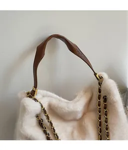 Détail de la texture en fausse fourrure blanche et poignée en cuir marron avec dorures