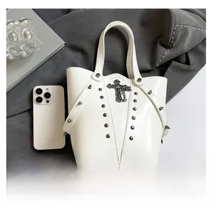 Top view of white bucket bag with metal studs, cross pendant and interior space