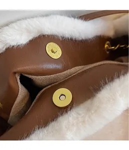Détail du fermoir magnétique doré sur sac en cuir marron avec bordure en fausse fourrure