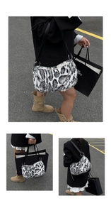 Détail du sac croissant en fausse fourrure léopard avec chaîne et large bandoulière