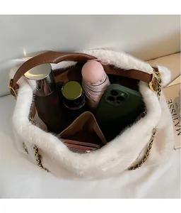 Intérieur spacieux du sac cabas en peluche blanche avec téléphone et parapluie