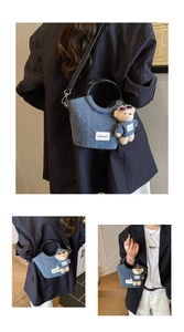 Detail view of denim bucket bag with circular handles and cute teddy bear charm accessory