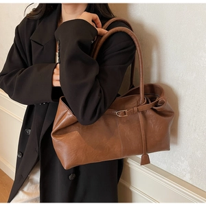 Détail d'un grand sac fourre-tout marron vintage avec boucle porté par un mannequin