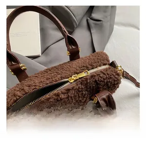 Gros plan détaillé sur la fermeture éclair dorée et le tissu en laine d'agneau du sac