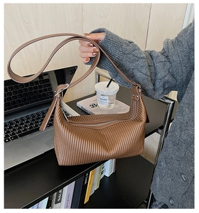 Detailed view of brown pleated PU leather texture on hobo bag with zipper closure